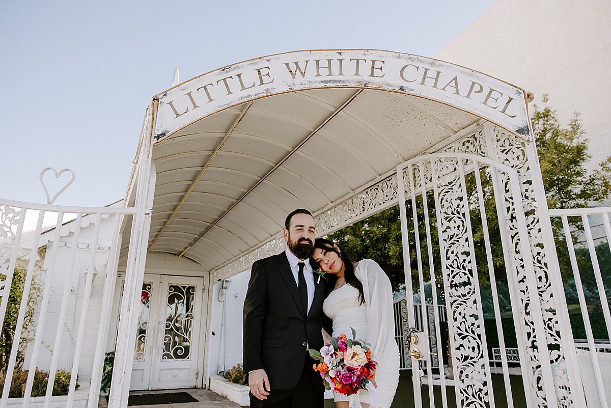 bride rests her head on grooms shoulder outside little white chapel las vegas