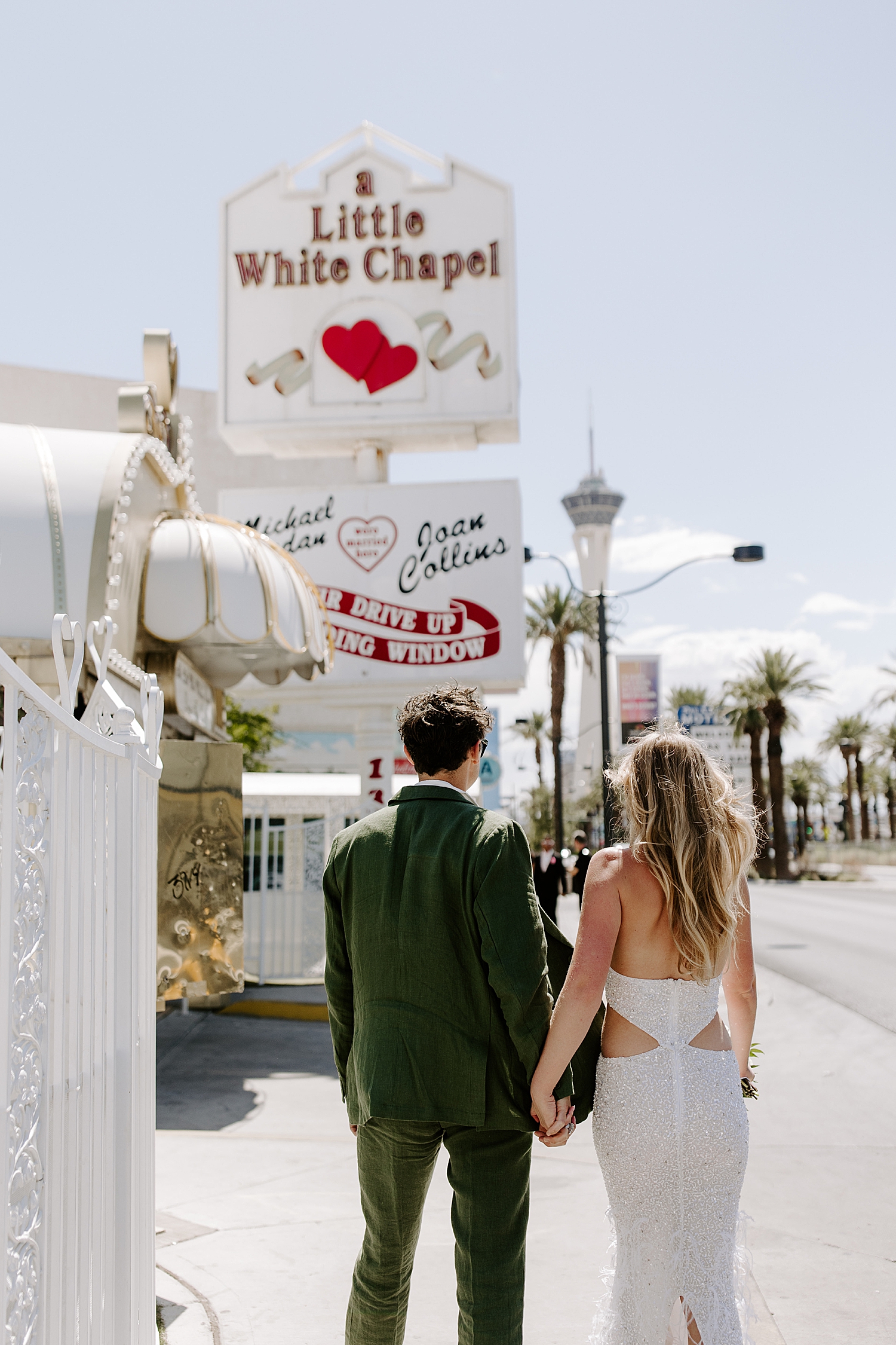 Newlyweds walk down sidewalk towards Bellagio reception