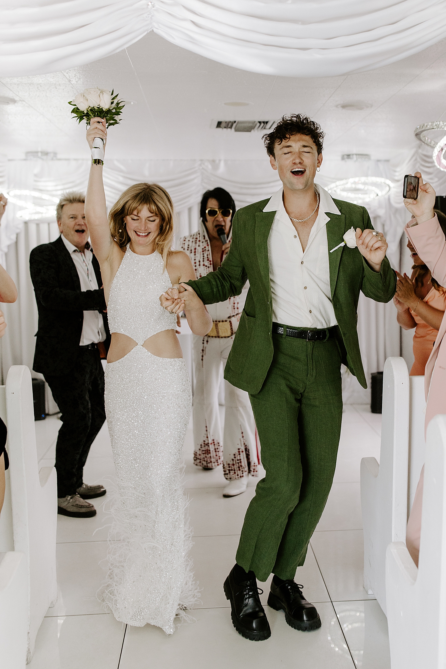 newlyweds dance down the aisle at LWC by Las Vegas wedding photographer