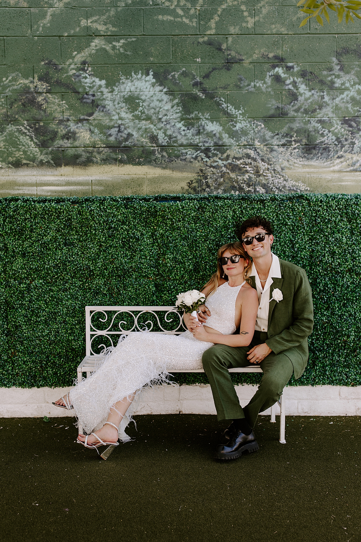 handsome couple sit on the bench outside LWC by Las Vegas wedding photographer