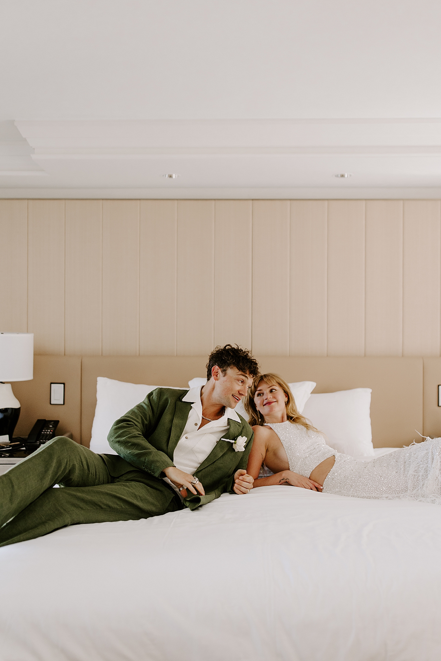 man and woman lie in bed after ceremony by Las Vegas wedding photographer