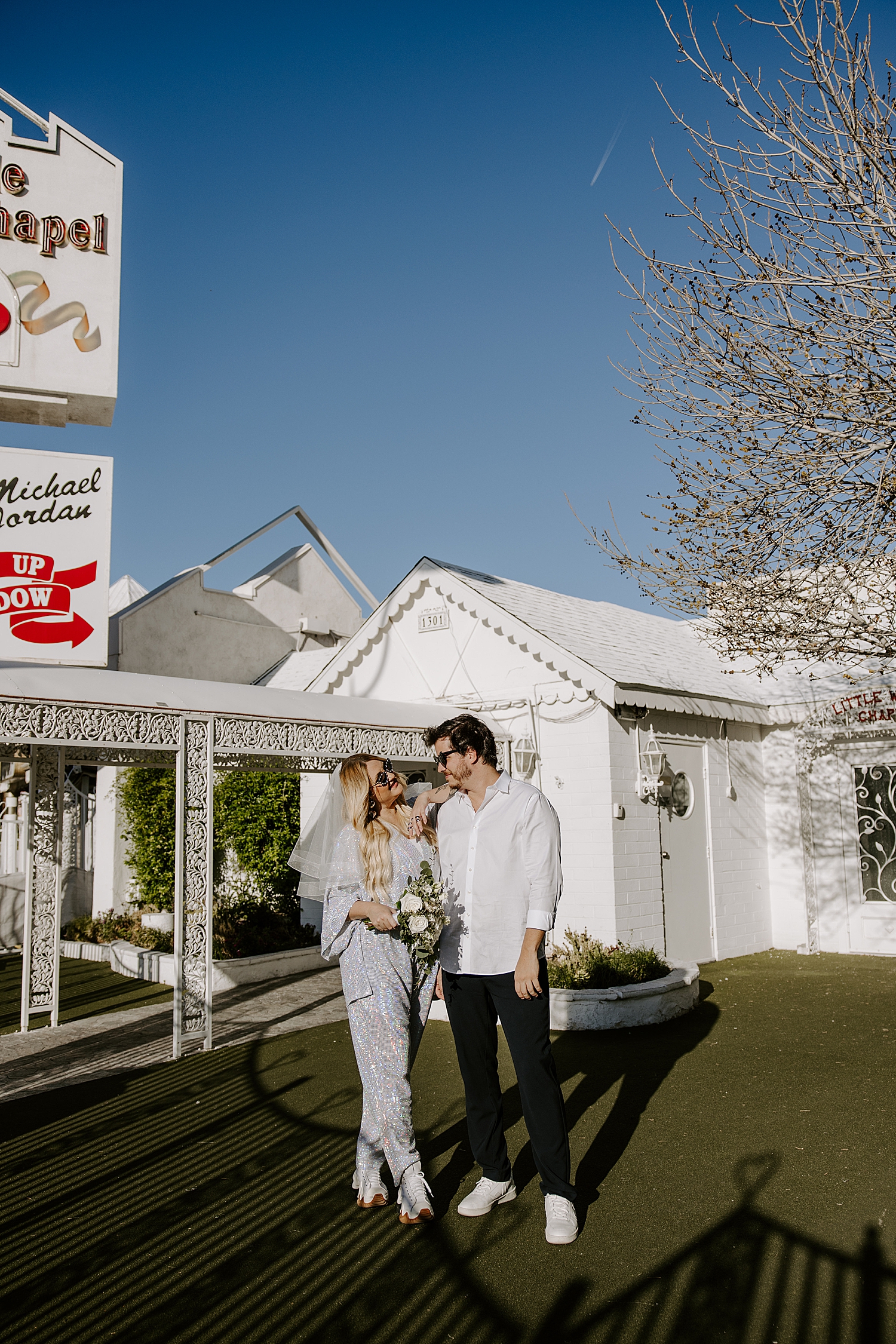 blonde bride in jumpsuit next to groom by Katelyn Faye Photo