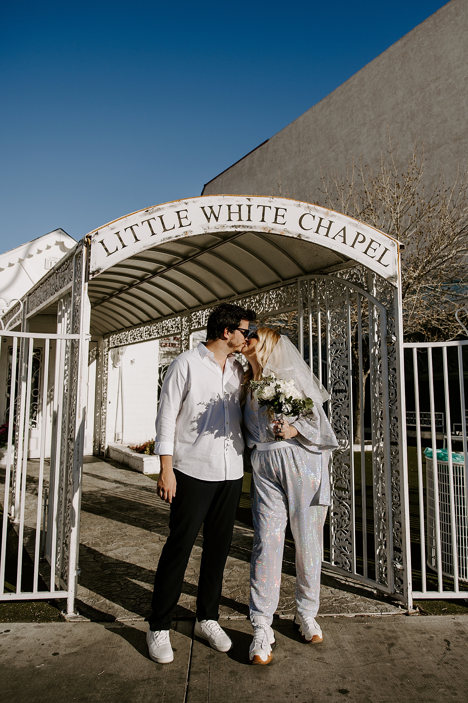 man and woman kiss under LWC sign by Las Vegas wedding photographer