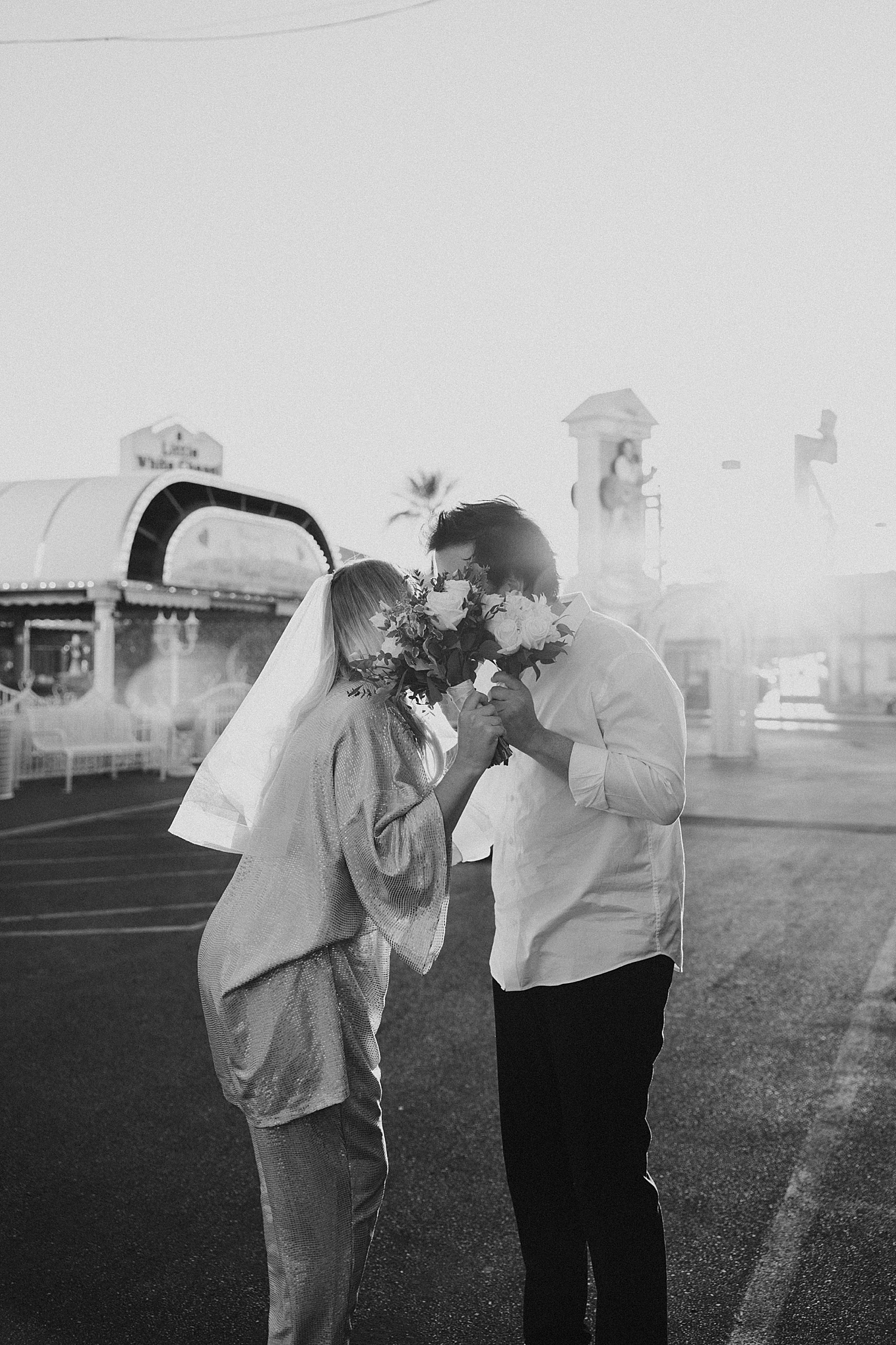 bride and groom kiss behind flowers by Katelyn Faye Photo