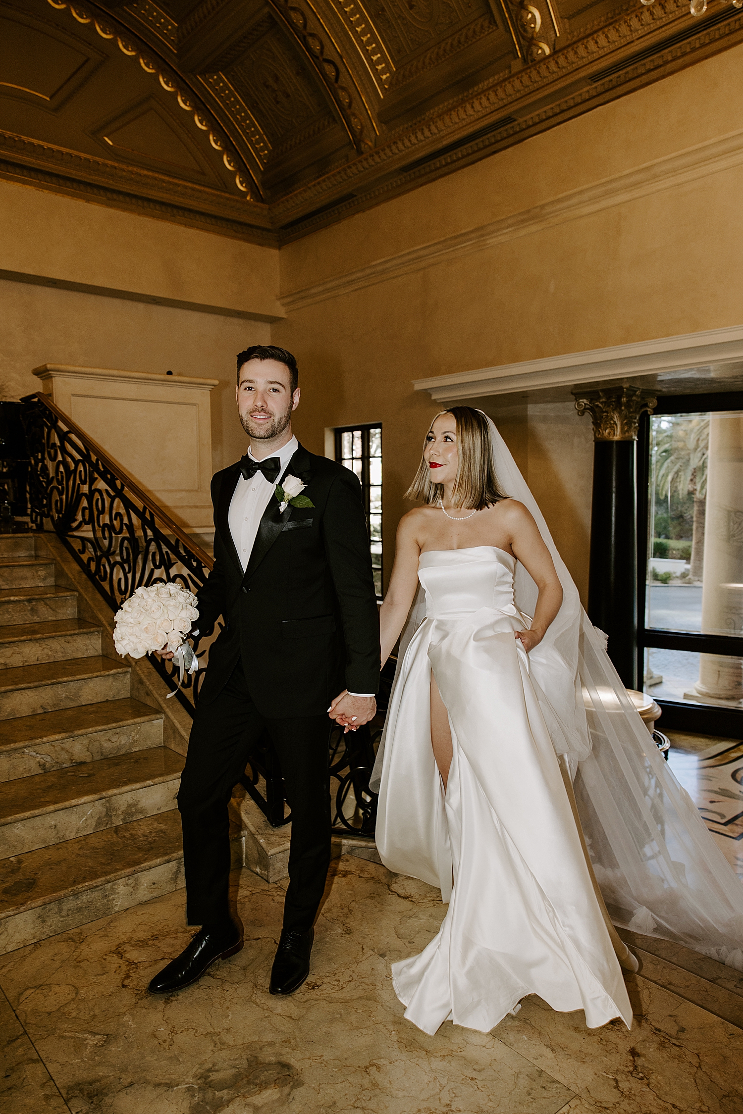 husband and wife walk through lobby by Las vegas wedding photographer