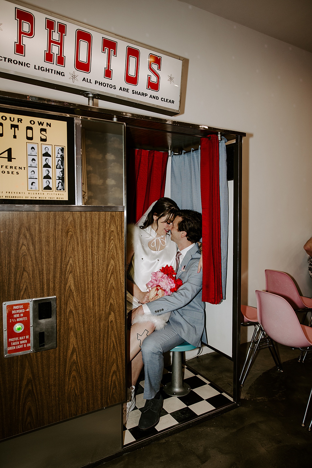 Couple sits in old time photo booth after their Vegas summer elopement