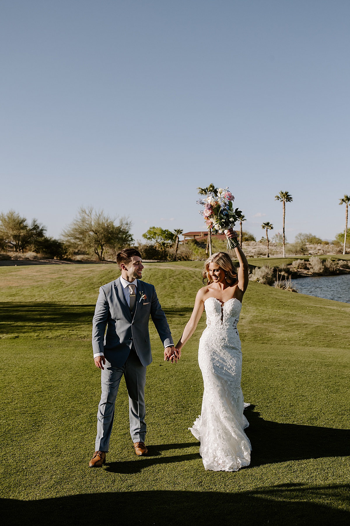 Couple celebrate their wedding day as woman raises bouquet in the air by Katelyn Faye Photography