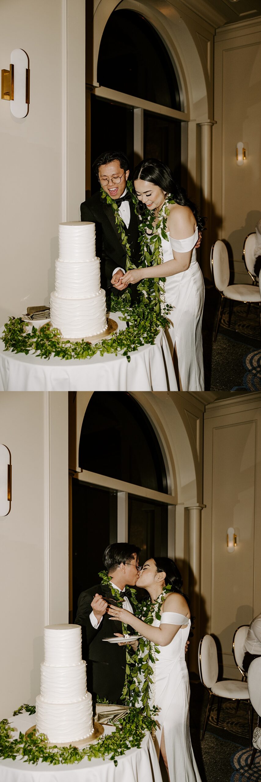 Newlyweds cut their white three-tiered cake surrounded by greenery by Las Vegas wedding photographer