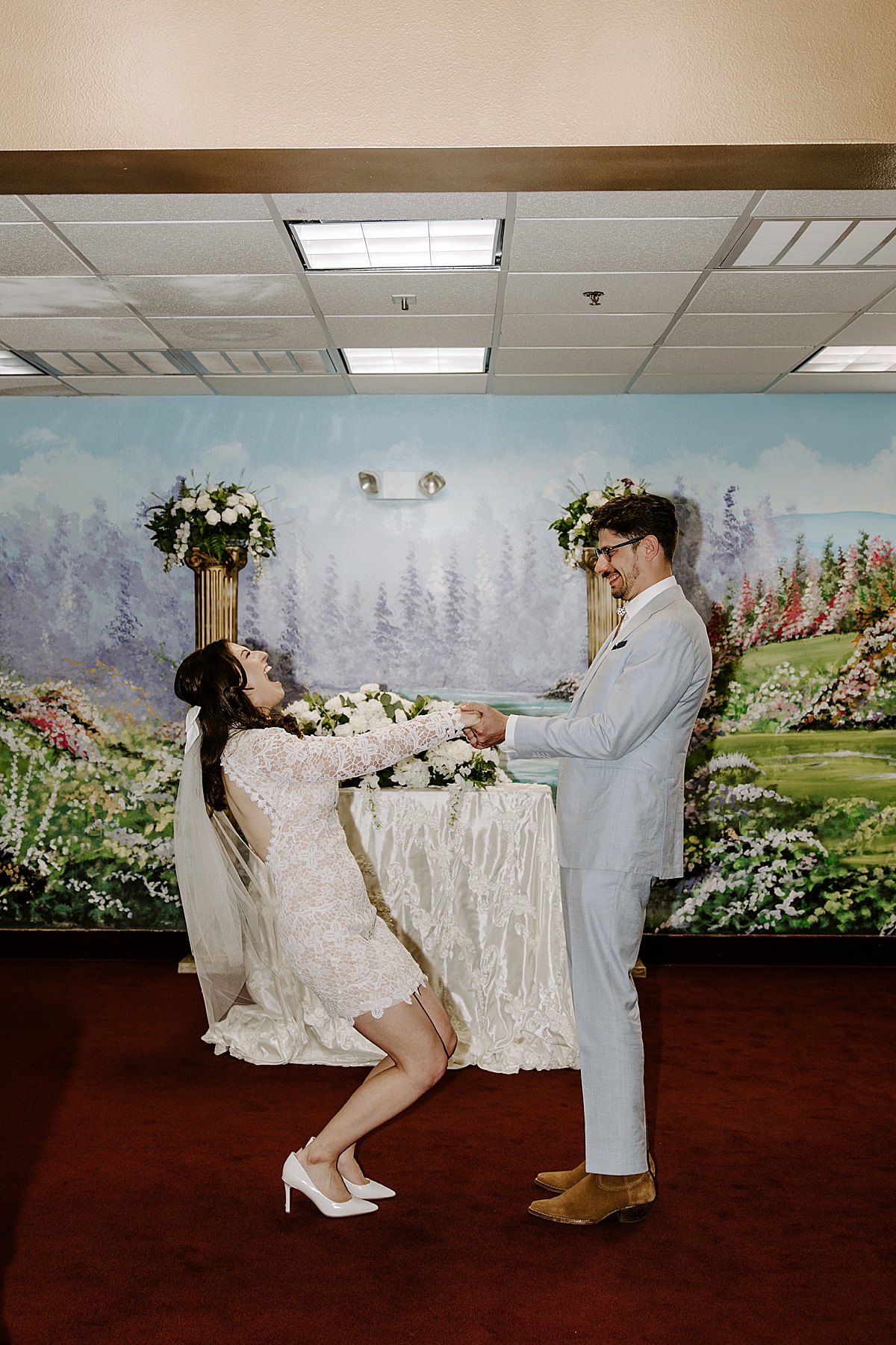 Woman holds hands with man at their ceremony and joyfully screams by las vegas wedding photographer