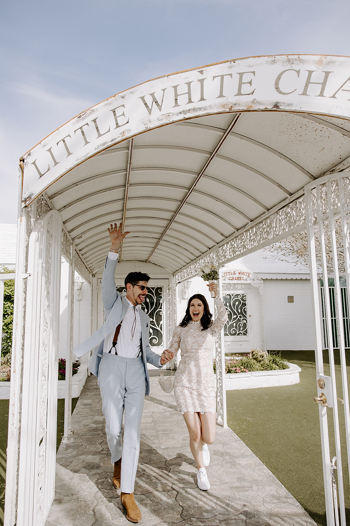 Man and woman hold hands and walk out of their wedding venue by Katelyn Faye Photo