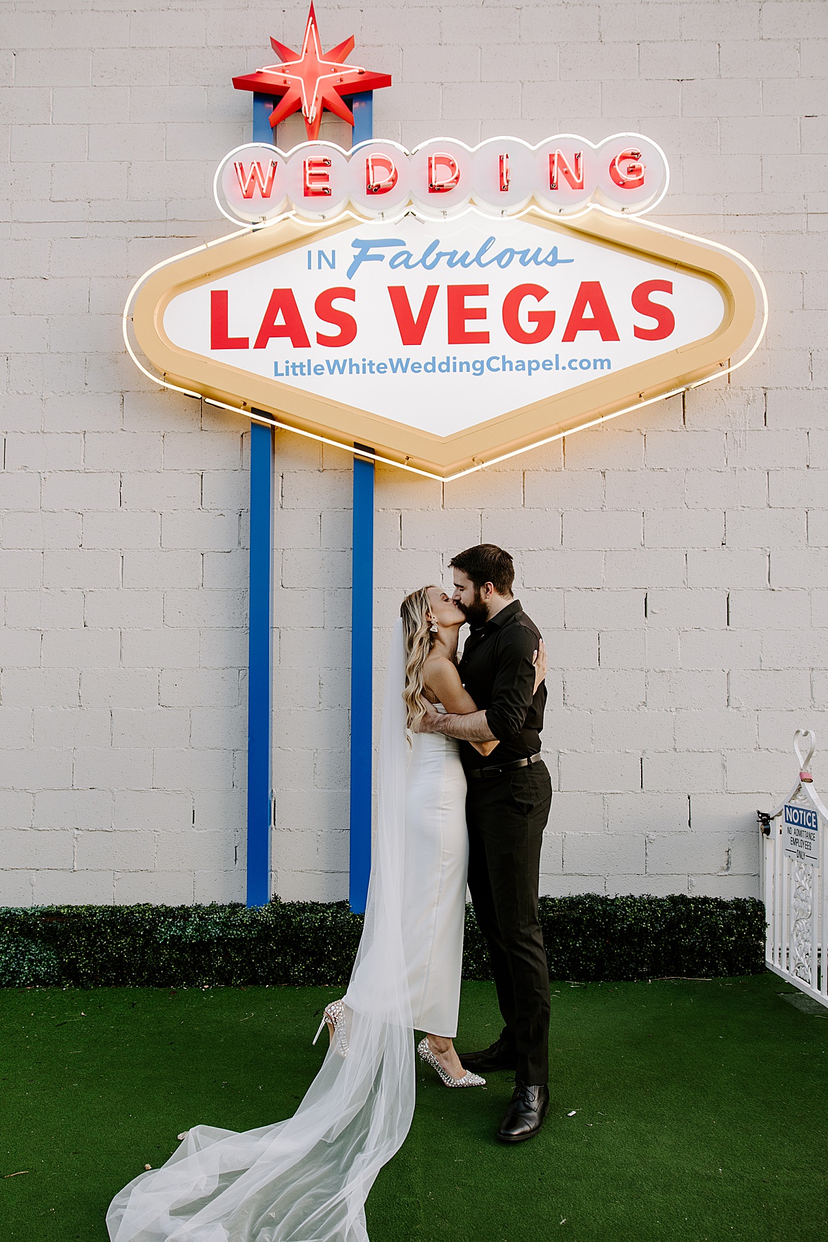 Man and woman kiss in front of the classic neon sign by Las Vegas Wedding Photographer