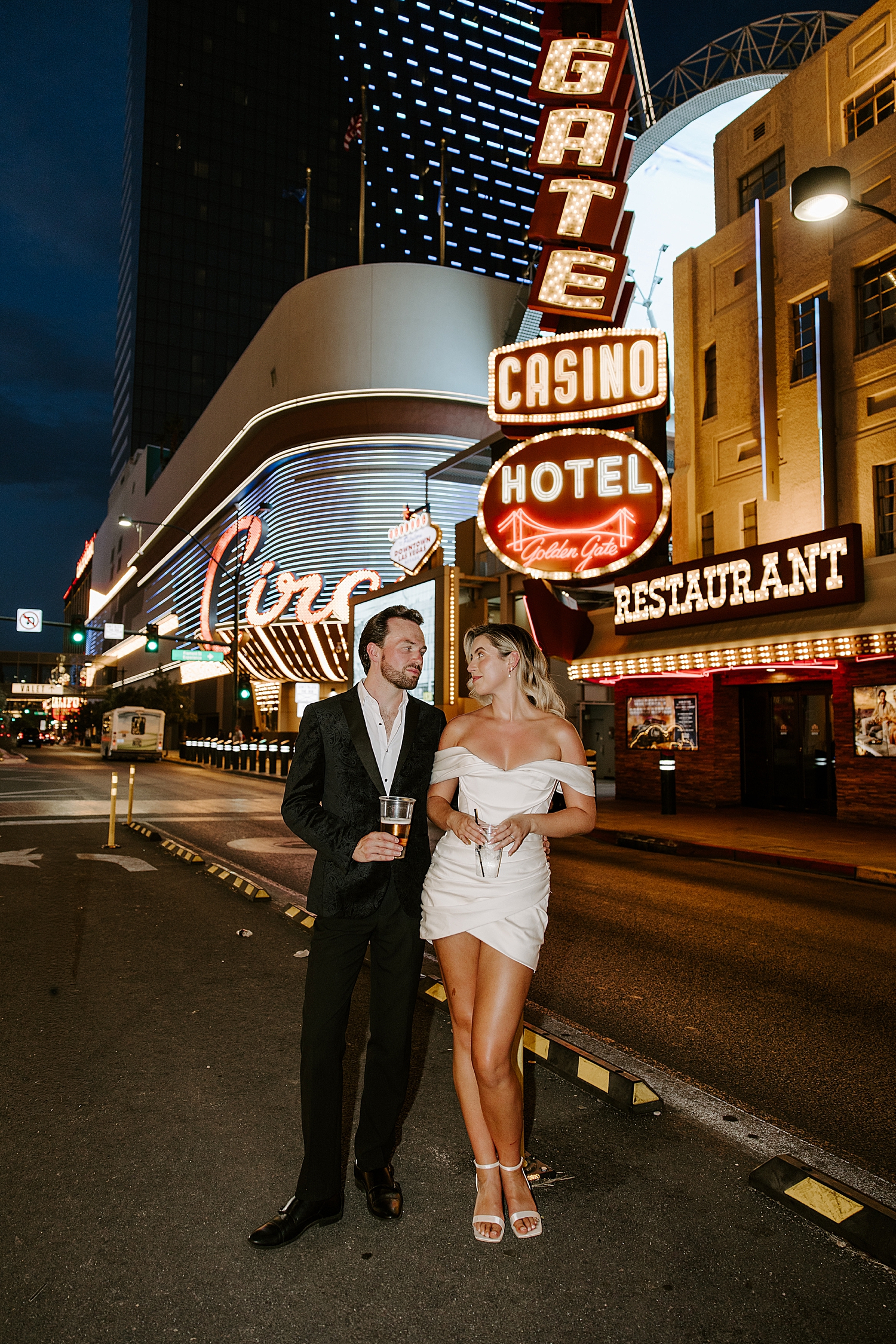 cuople stands in front of casino sign for Fremont Anniversary Session