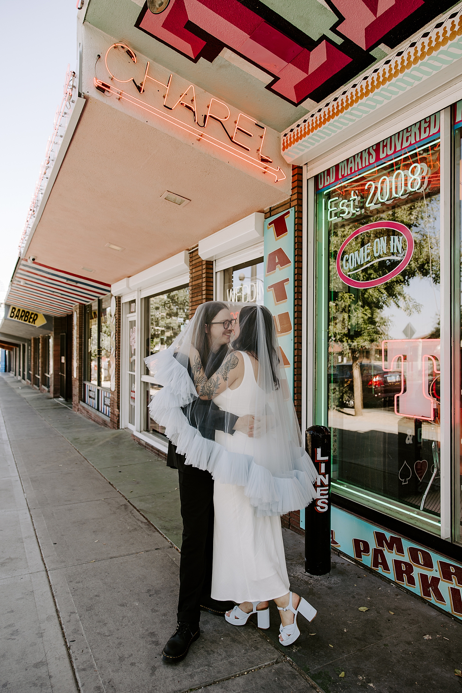 couple stands on Fremont street after ceremony with clothing that have vintage vibes