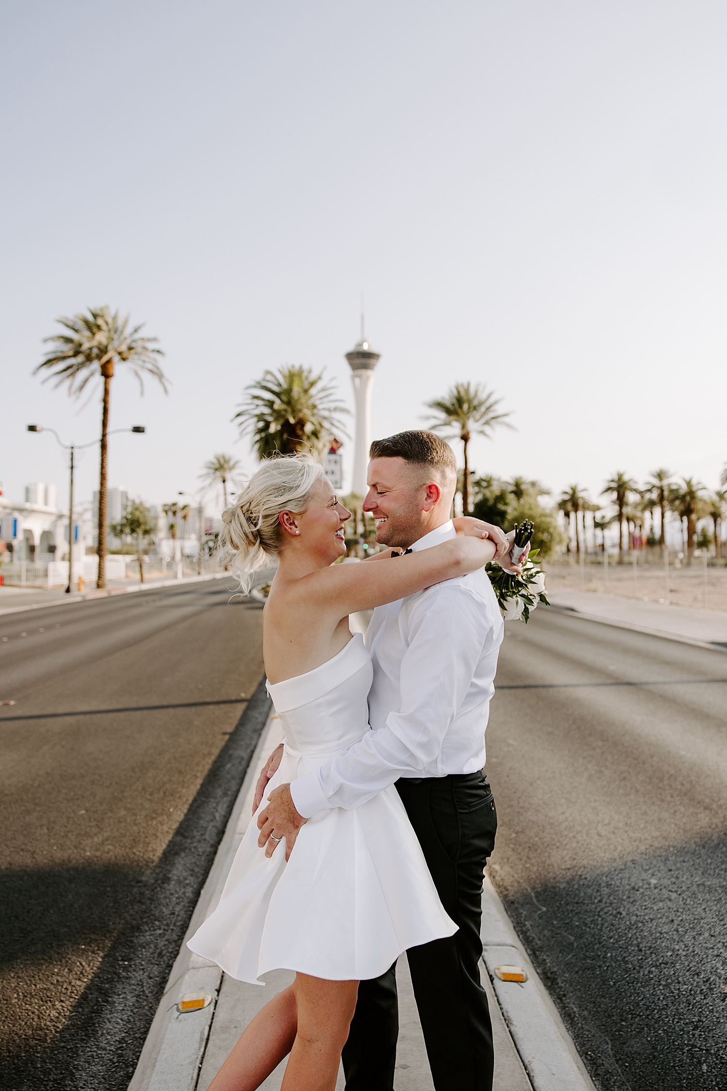 man holds woman close in the street by Las Vegas wedding photographer