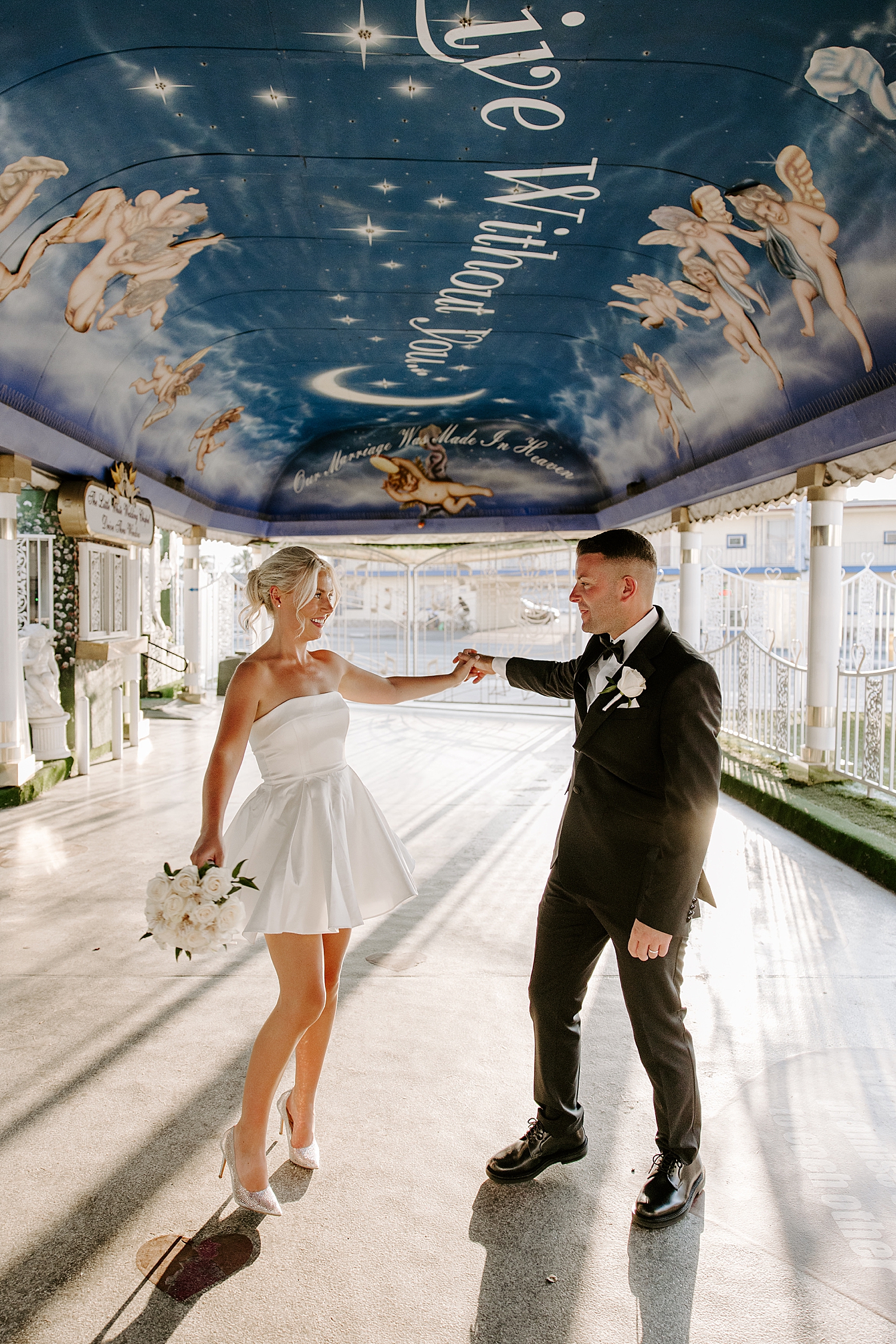 newlyweds dance under painted awning by Katelyn Faye Photography