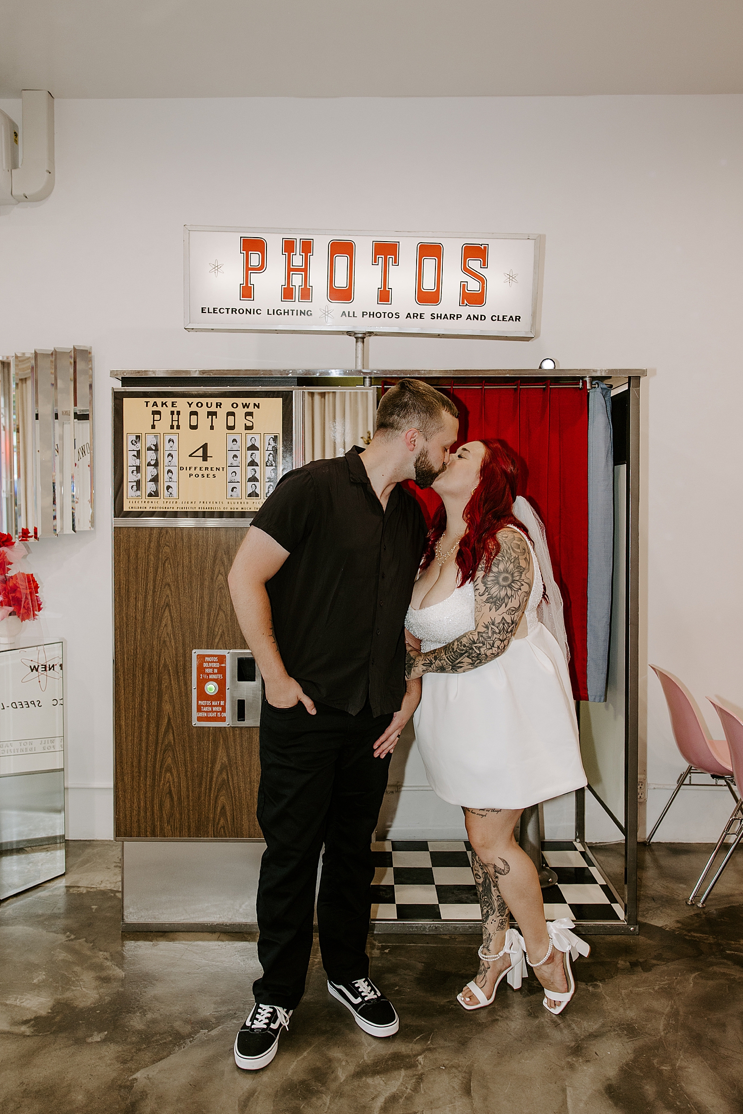 man and woman share a kiss outside a photobooth by Las Vegas Elopement Photographer