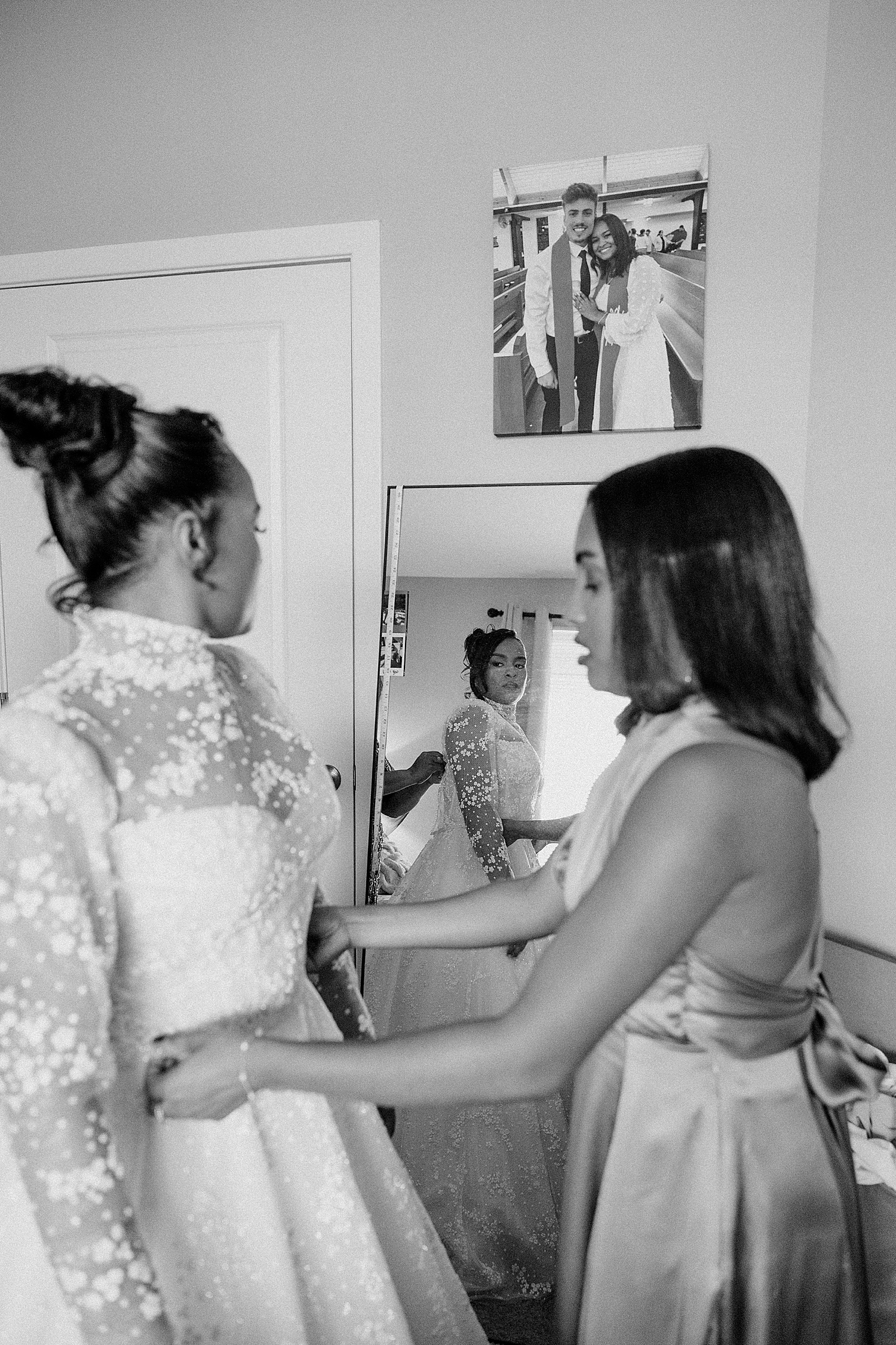 bridesmaid adjusts lace feature on bride's dress by Katelyn Faye Photography