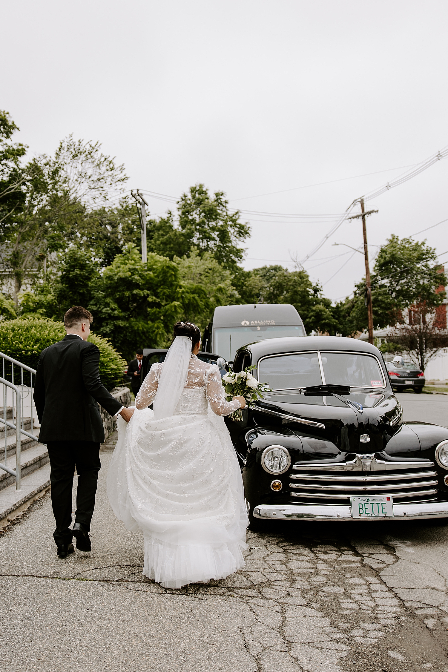man and wife walk towards old timey car on the street by Katelyn Faye Photography