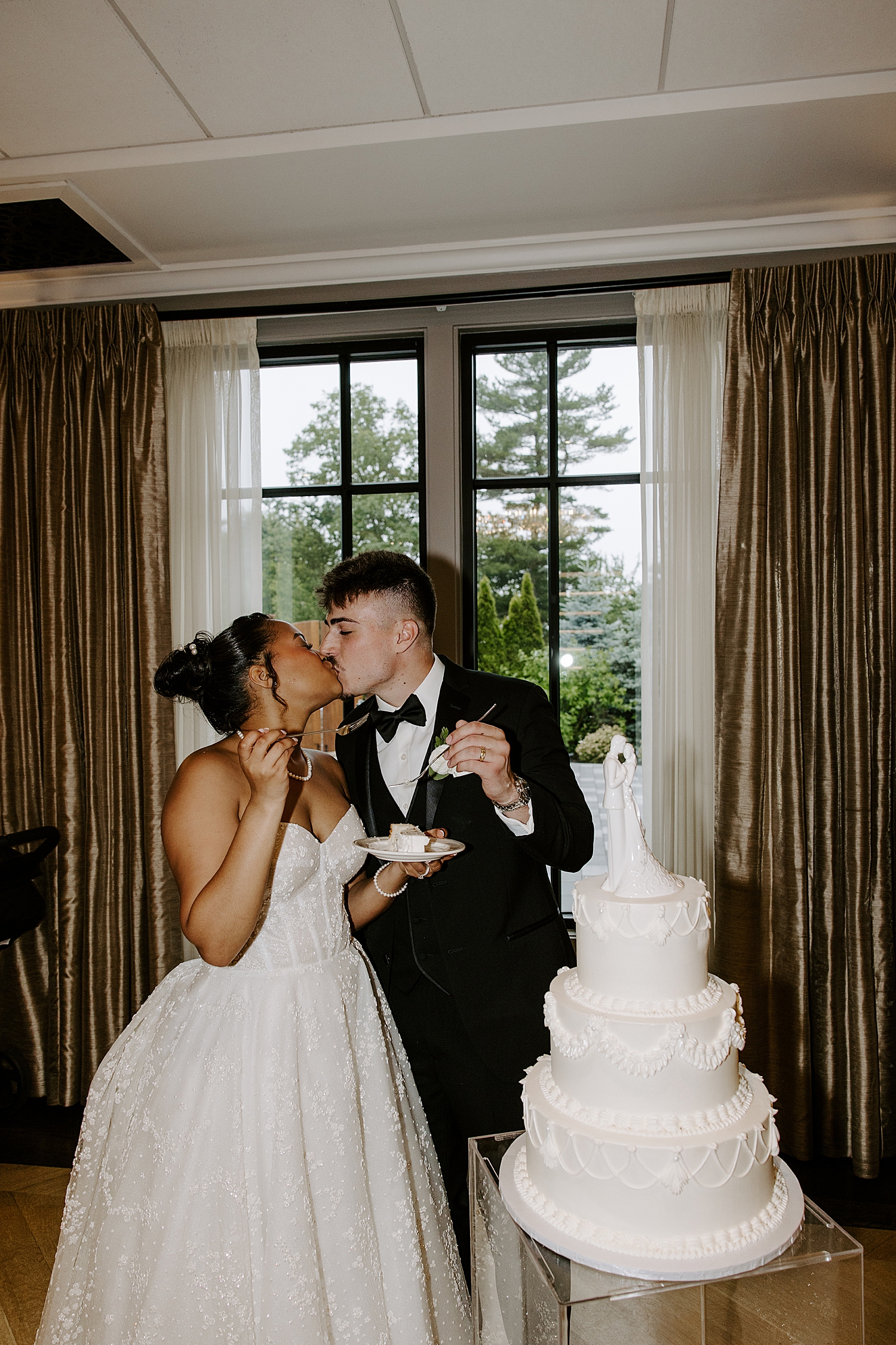 newlyweds cut their three tier white cake together at Boston Wedding