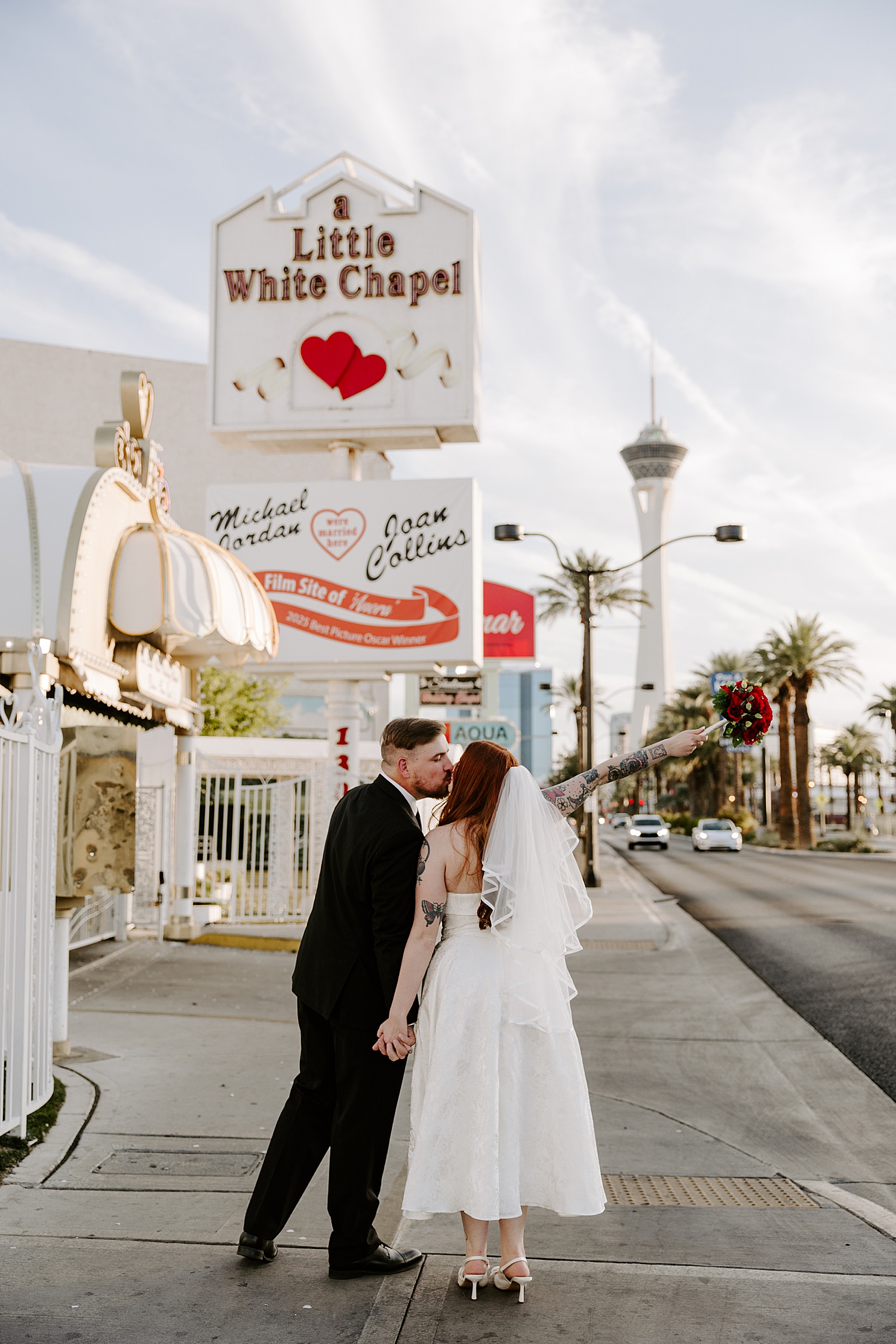 newlyweds share a kiss under chapel signs by Katelyn Faye Photo
