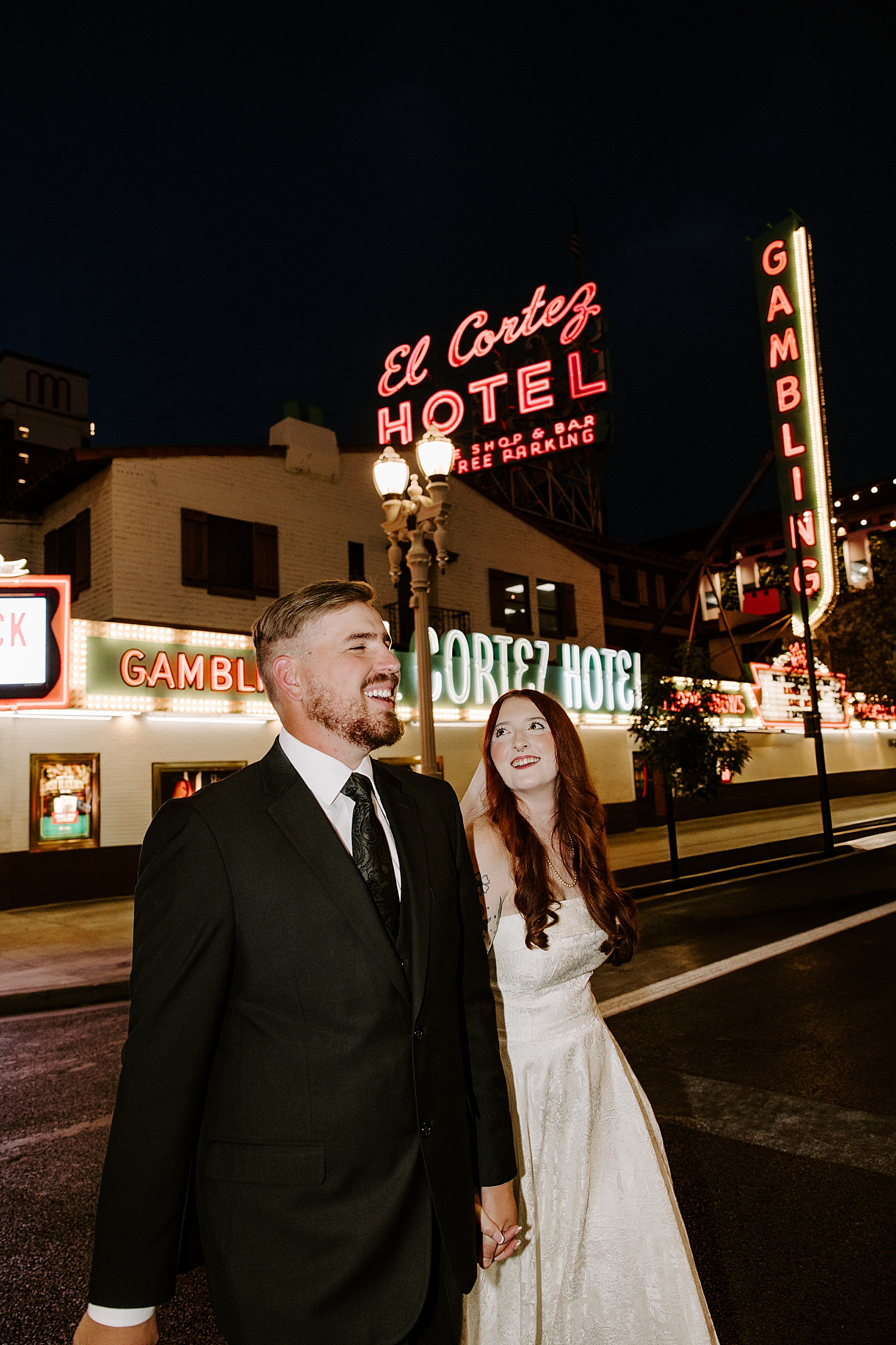 woman looks up at her new husband under neon lights by Katelyn Faye Photo