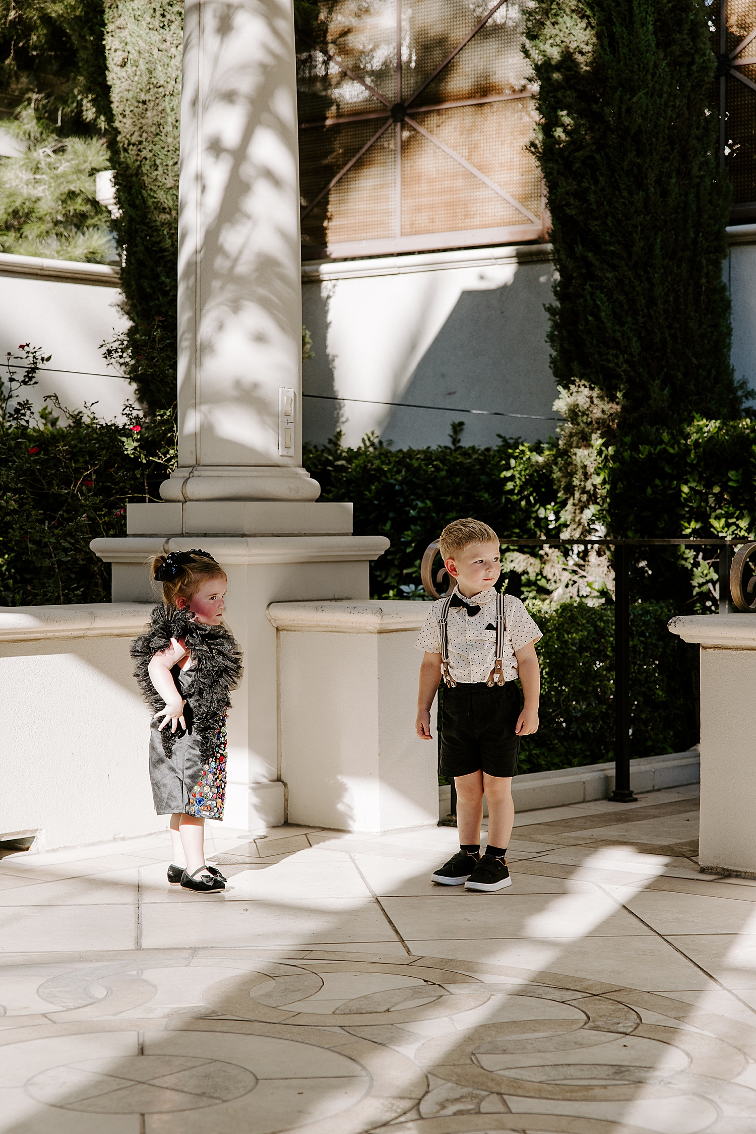 two little kids stand by a pillar in Juno Garden