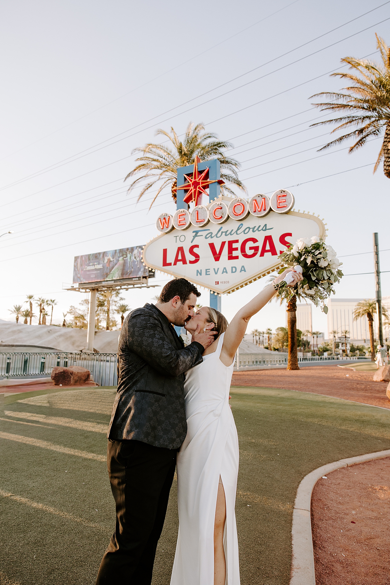 man and woman share a kiss under neon sign after ceremony in Juno Garden