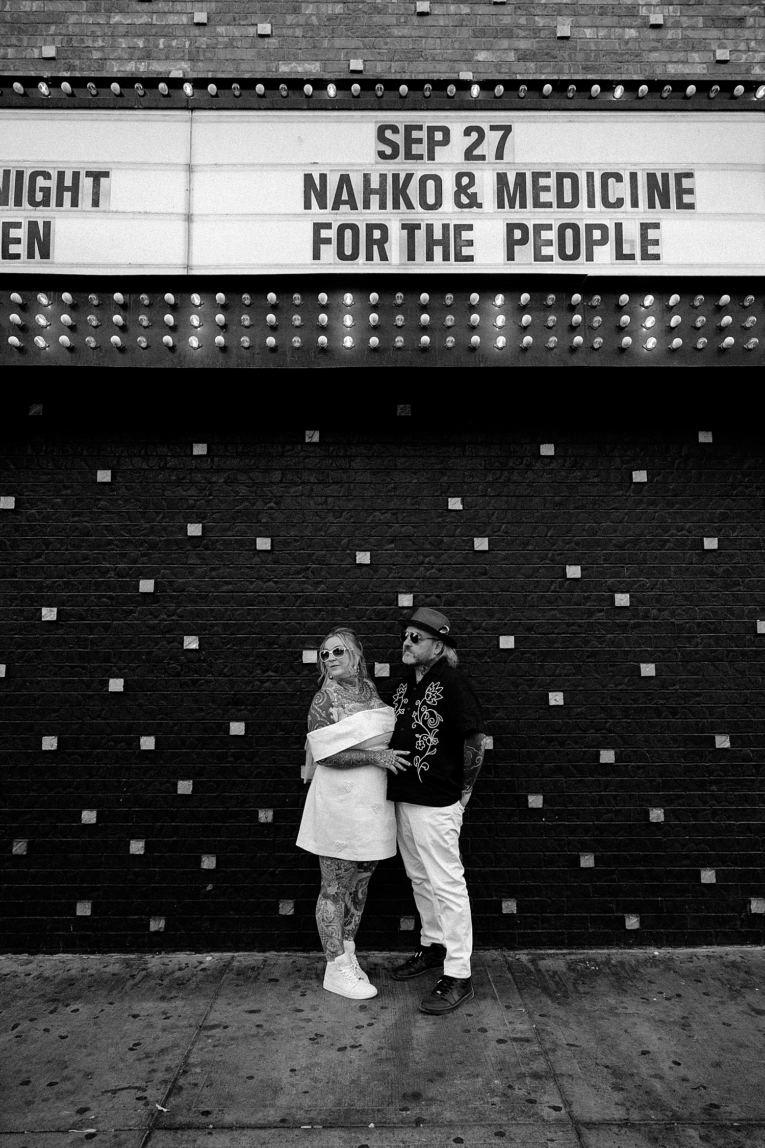 newlyweds stand in front of black wall on fremont street by Las Vegas Wedding Photographer