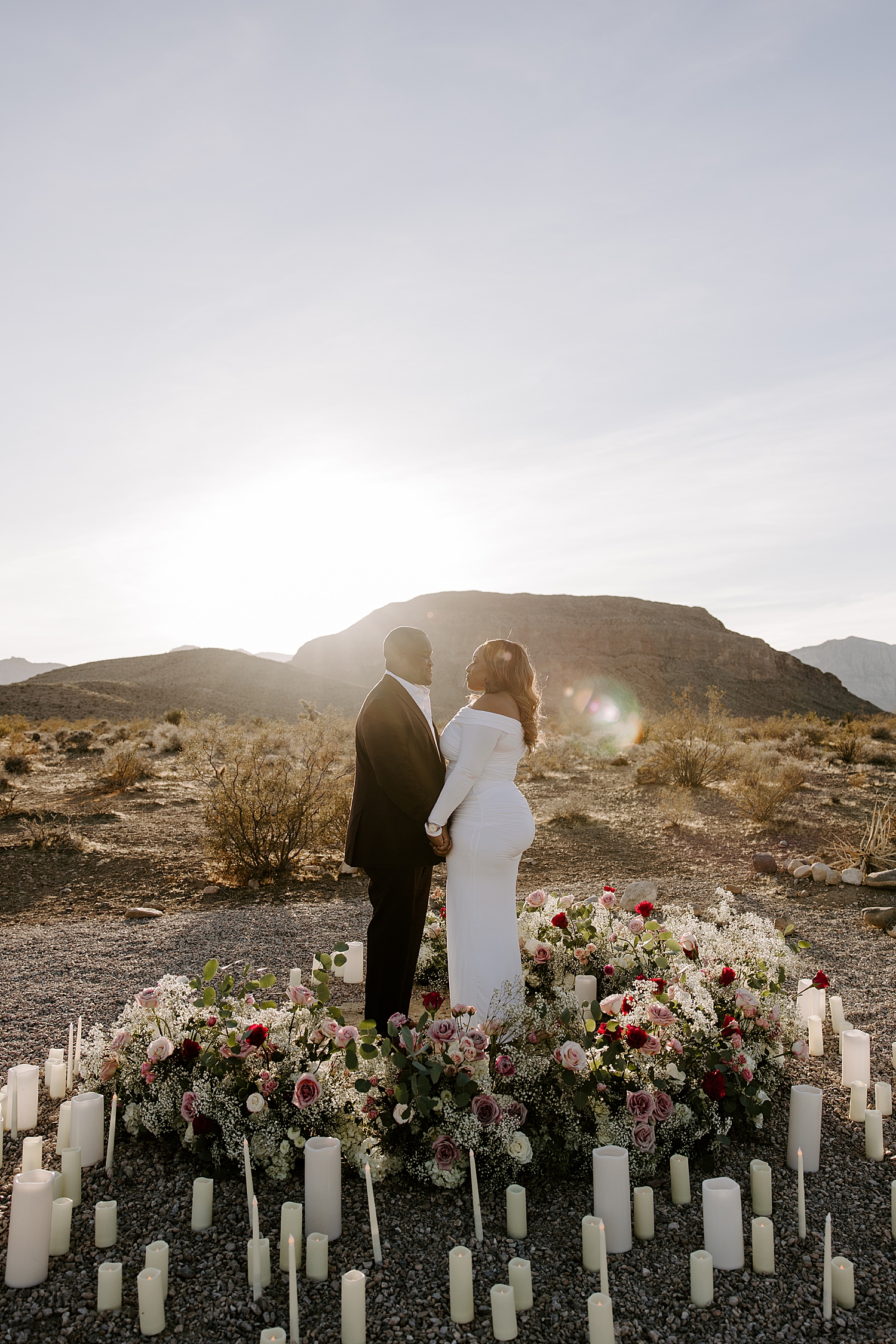 man and woman hold hands surrounded by flowers in the desert by las vegas wedding photographer