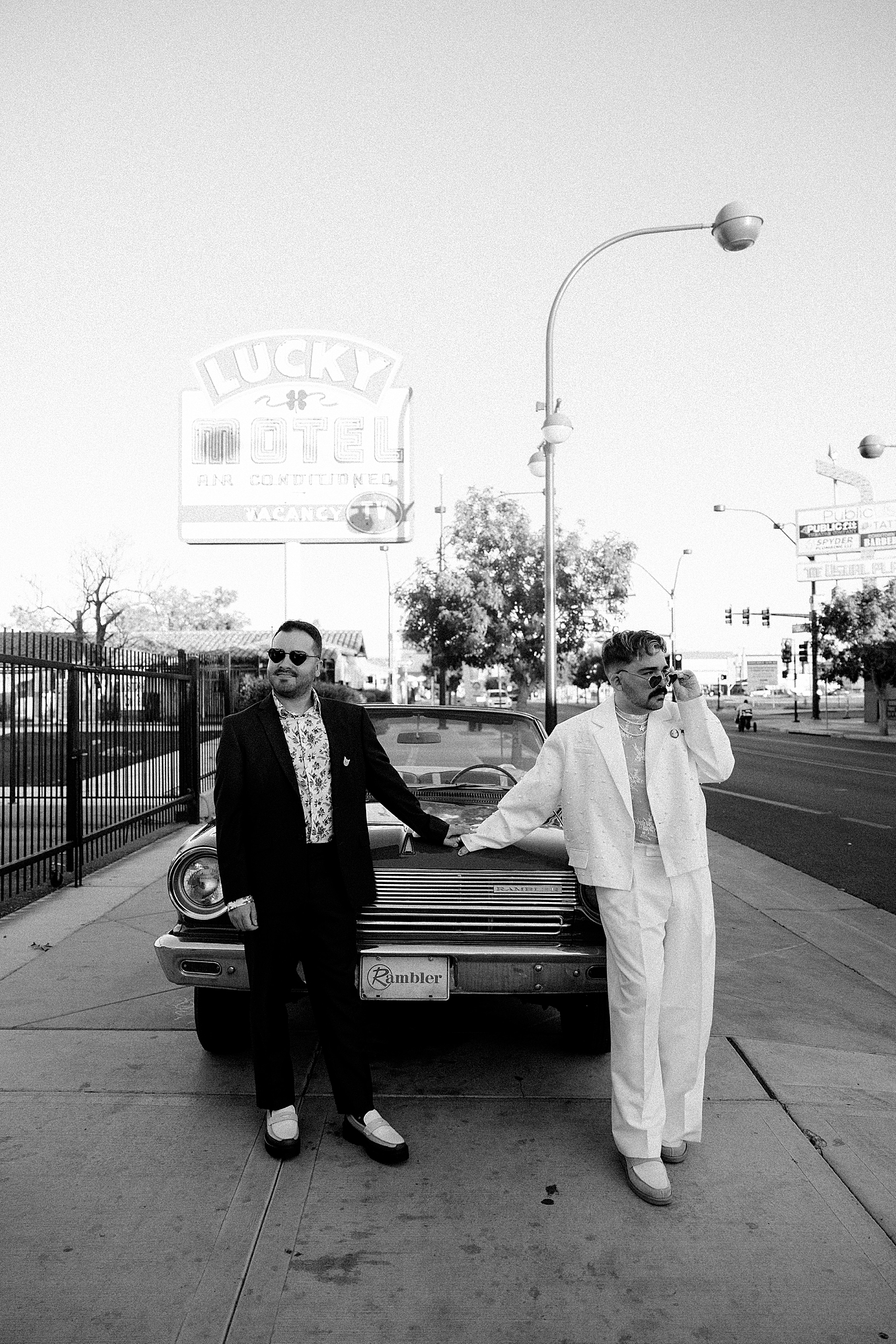 husbands lean against old sports car by Las Vegas elopement photographer