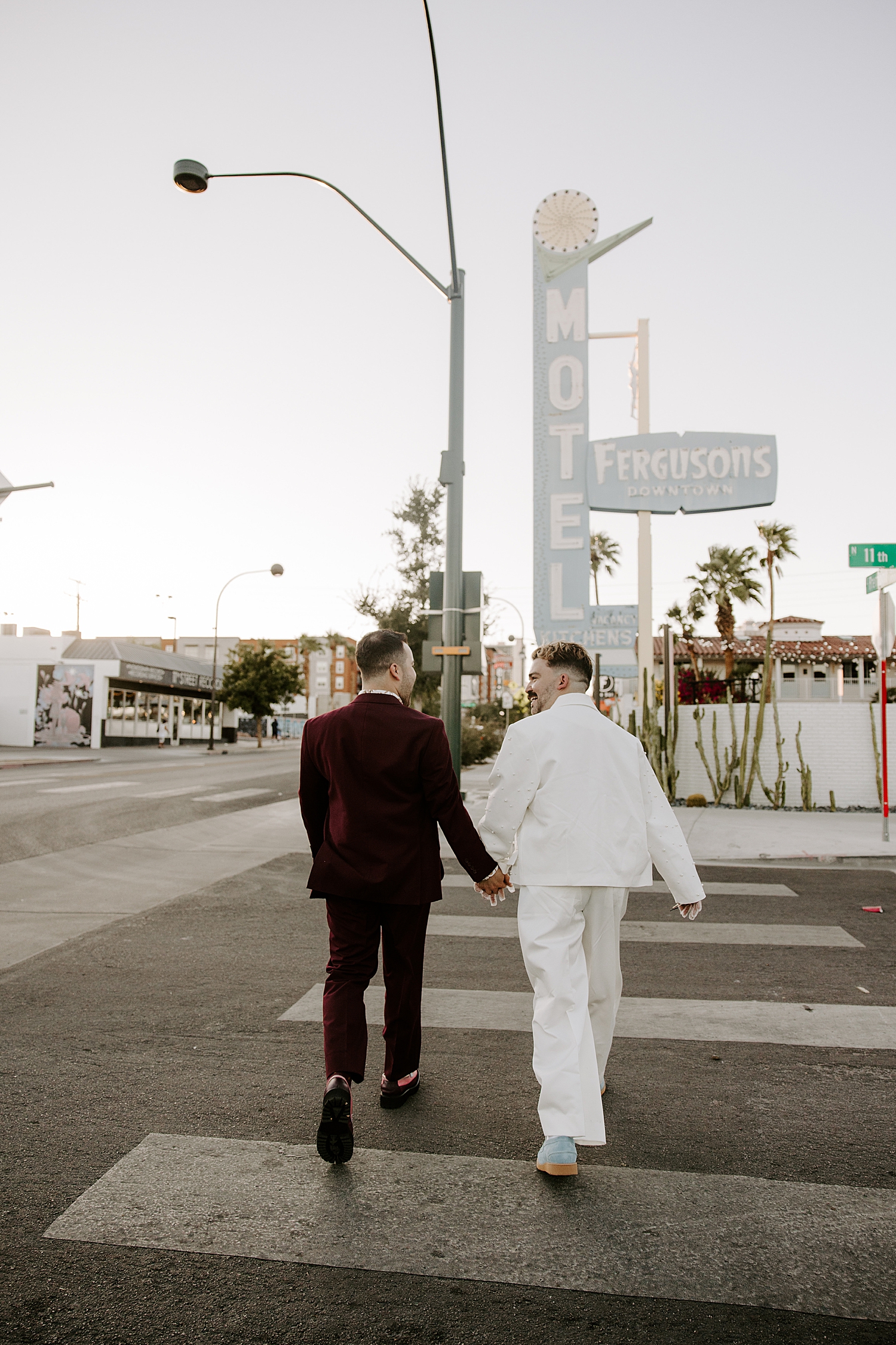 two men walk across street hand in hand by Las Vegas elopement photographer