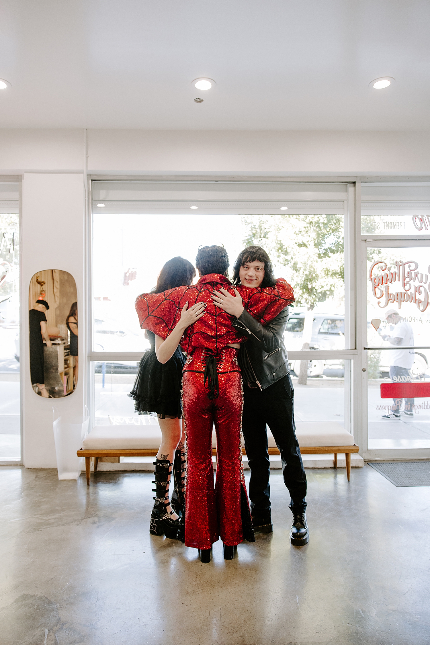 impersonator in red sparks hugs bride and groom by Katelyn Faye Photo