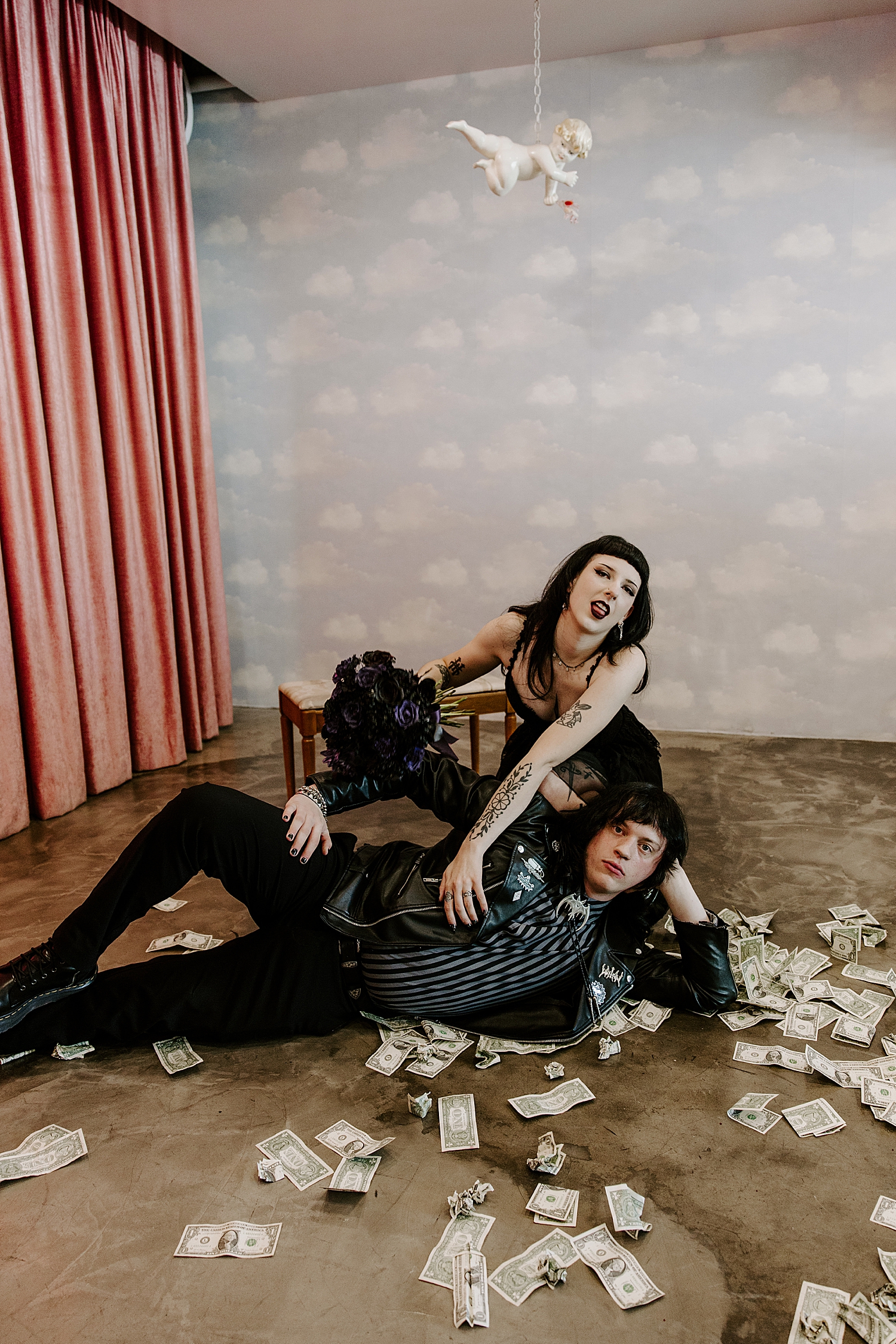 newlyweds pose on the floor covered in money by Katelyn Faye Photo
