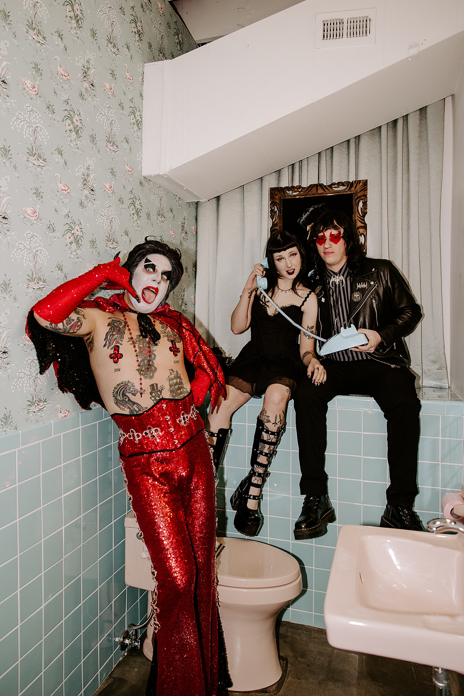 man in red mocks couple playfully in mint bathroom for elopement with Hellvis