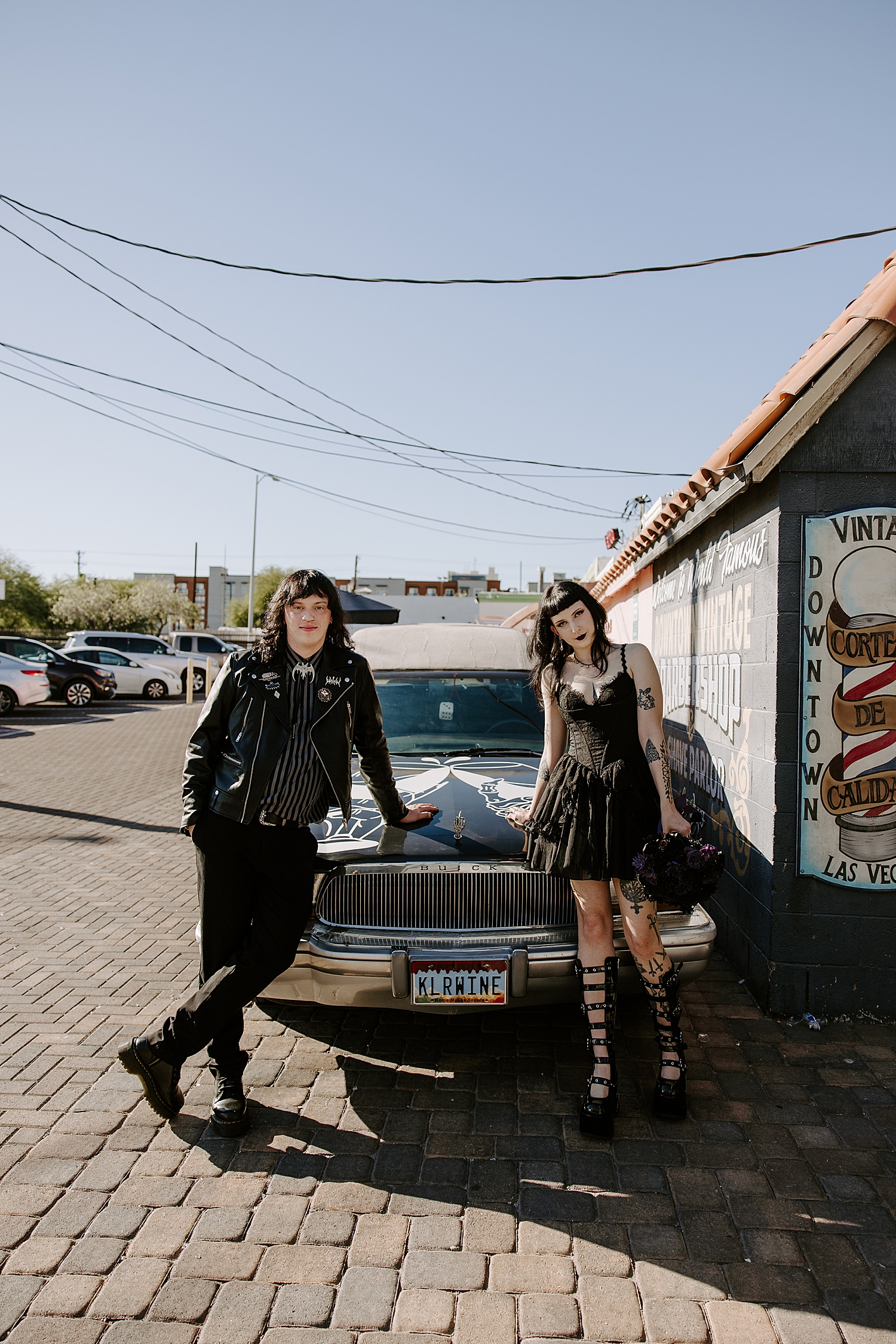 couple in full black stand in front of hurst for elopement with Hellvis