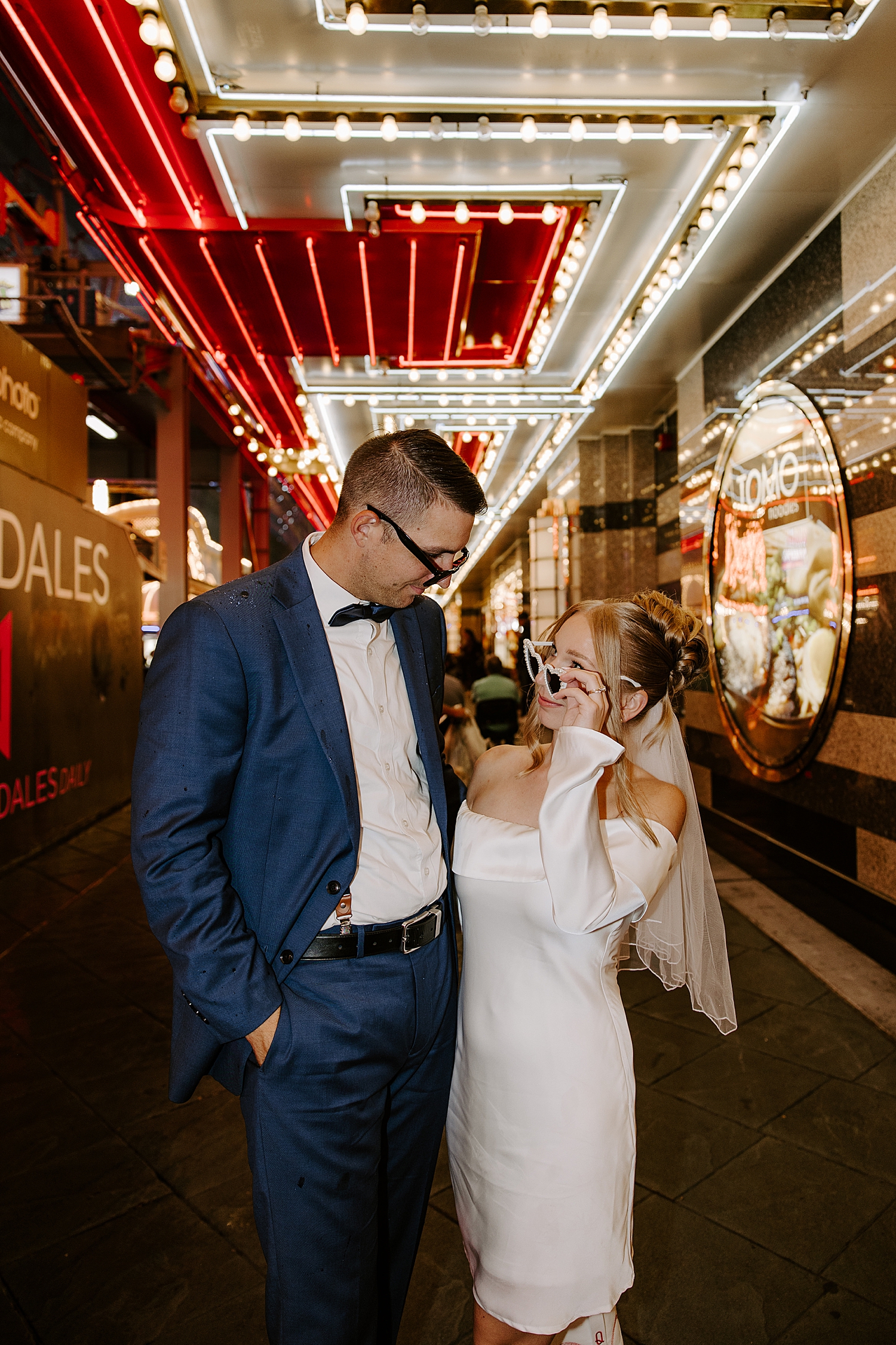 woman in glasses looks over are her man under neon lights by Katelyn Faye Photo