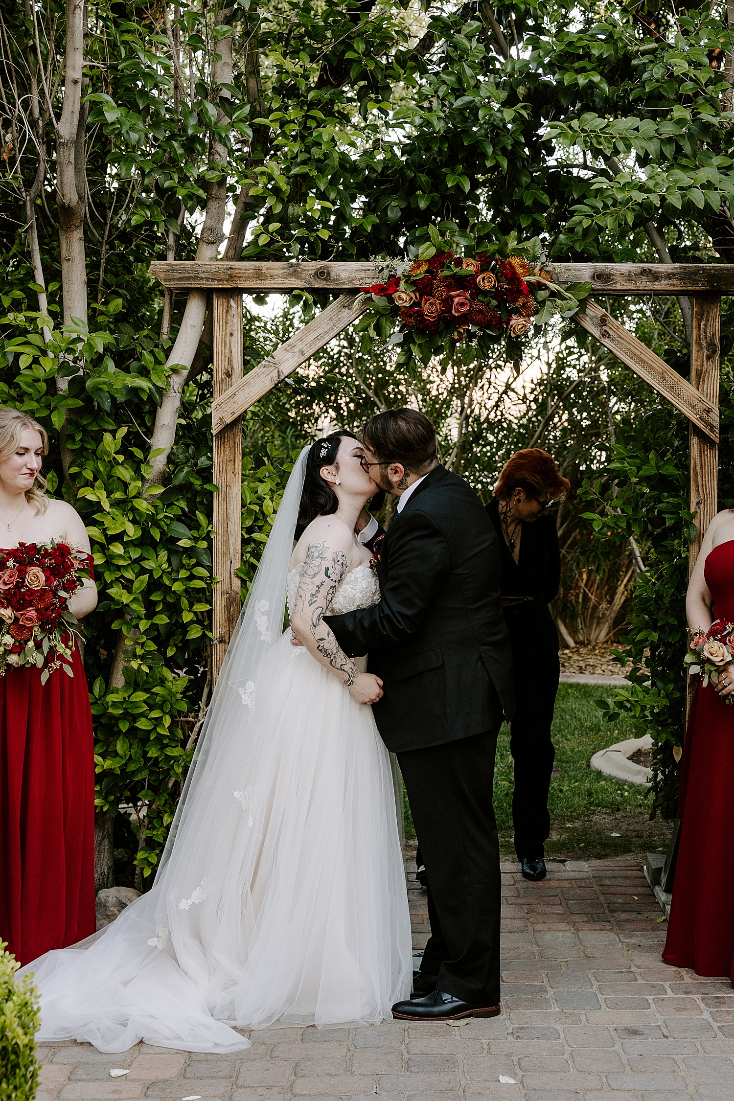 newlyweds share a kiss under wooden alter by Las Vegas wedding photographer