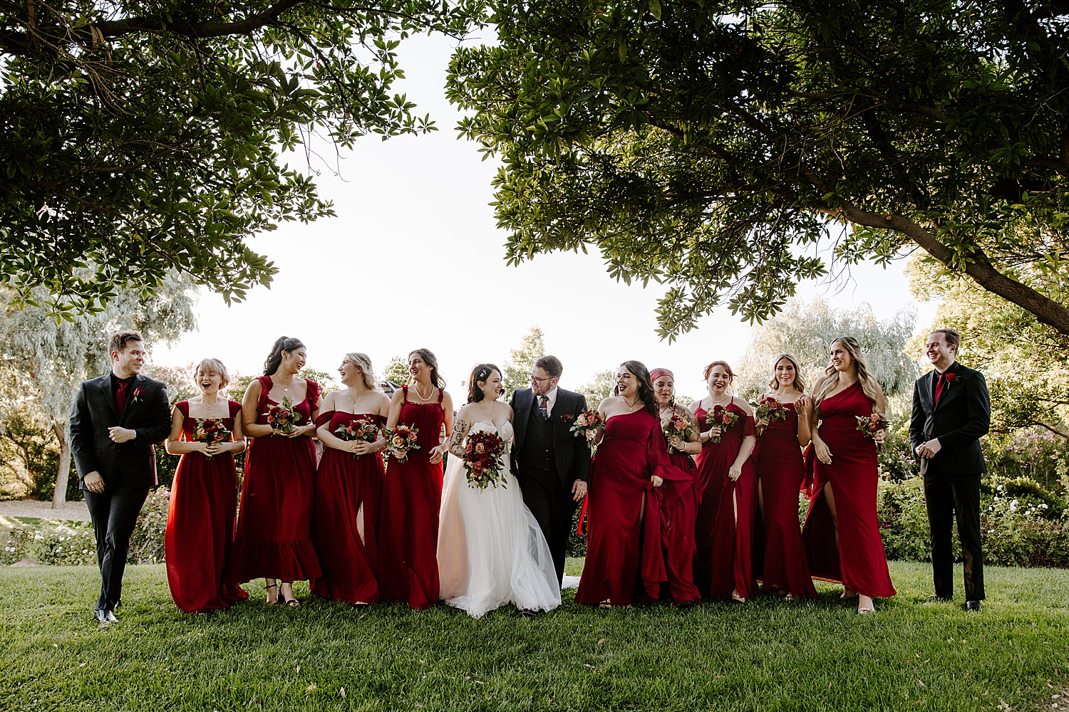 man and woman stand with their bridal party on lawn by Katelyn Faye Photography