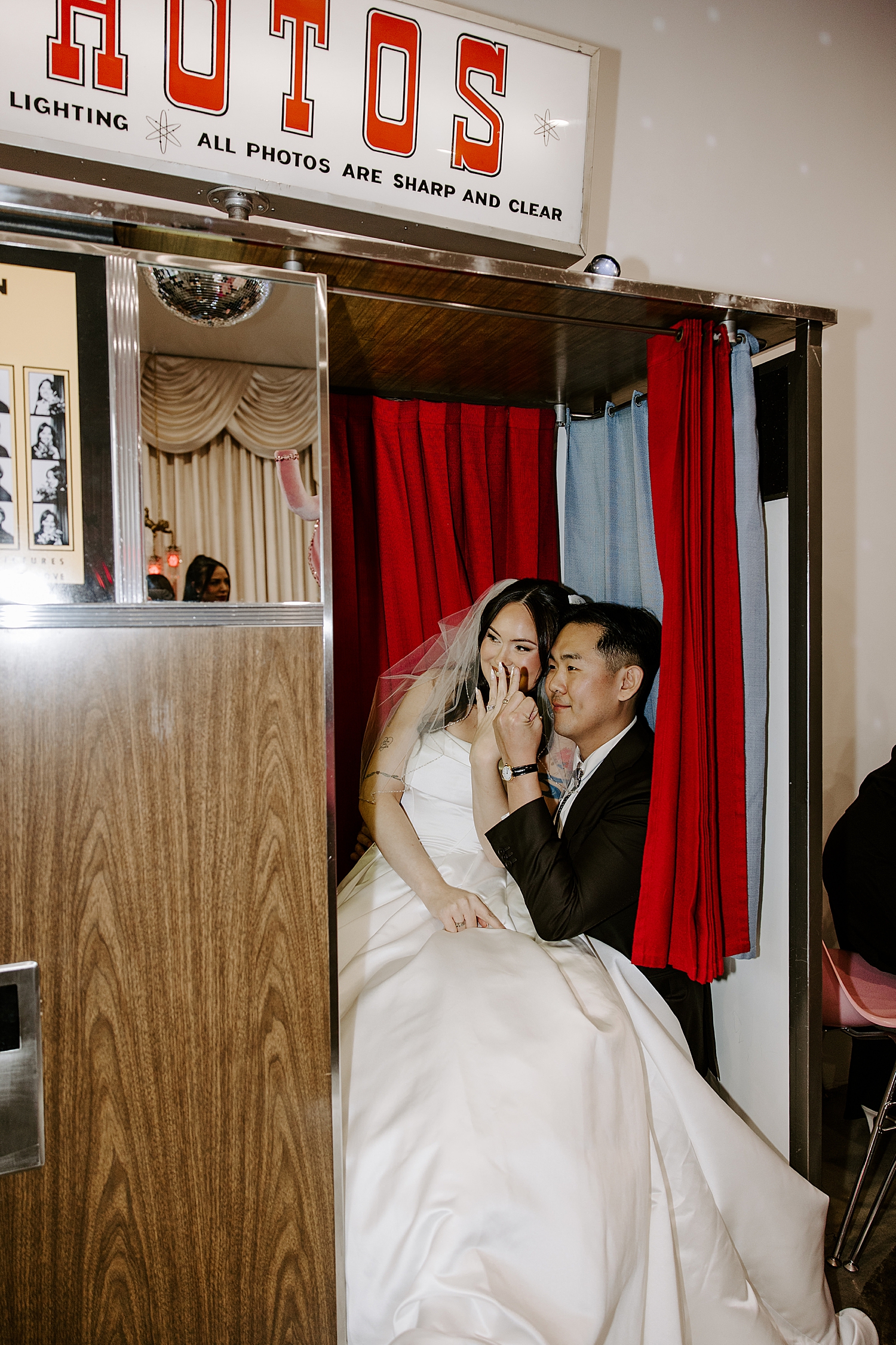newlyweds show off their rings in photo booth before fun-filled celebration