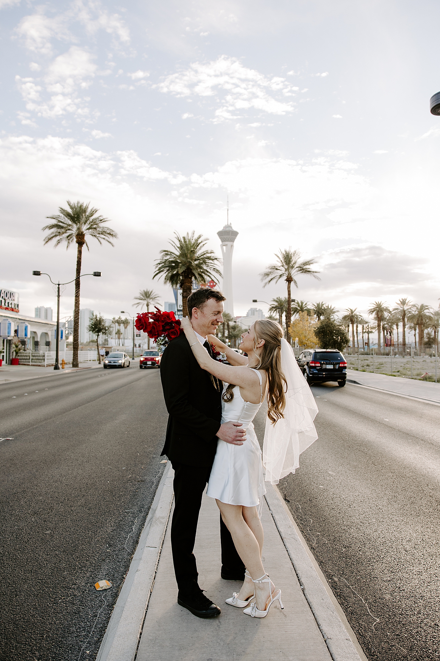 newlyweds share a kiss in the street in front of LWC by Las Vegas wedding photographer
