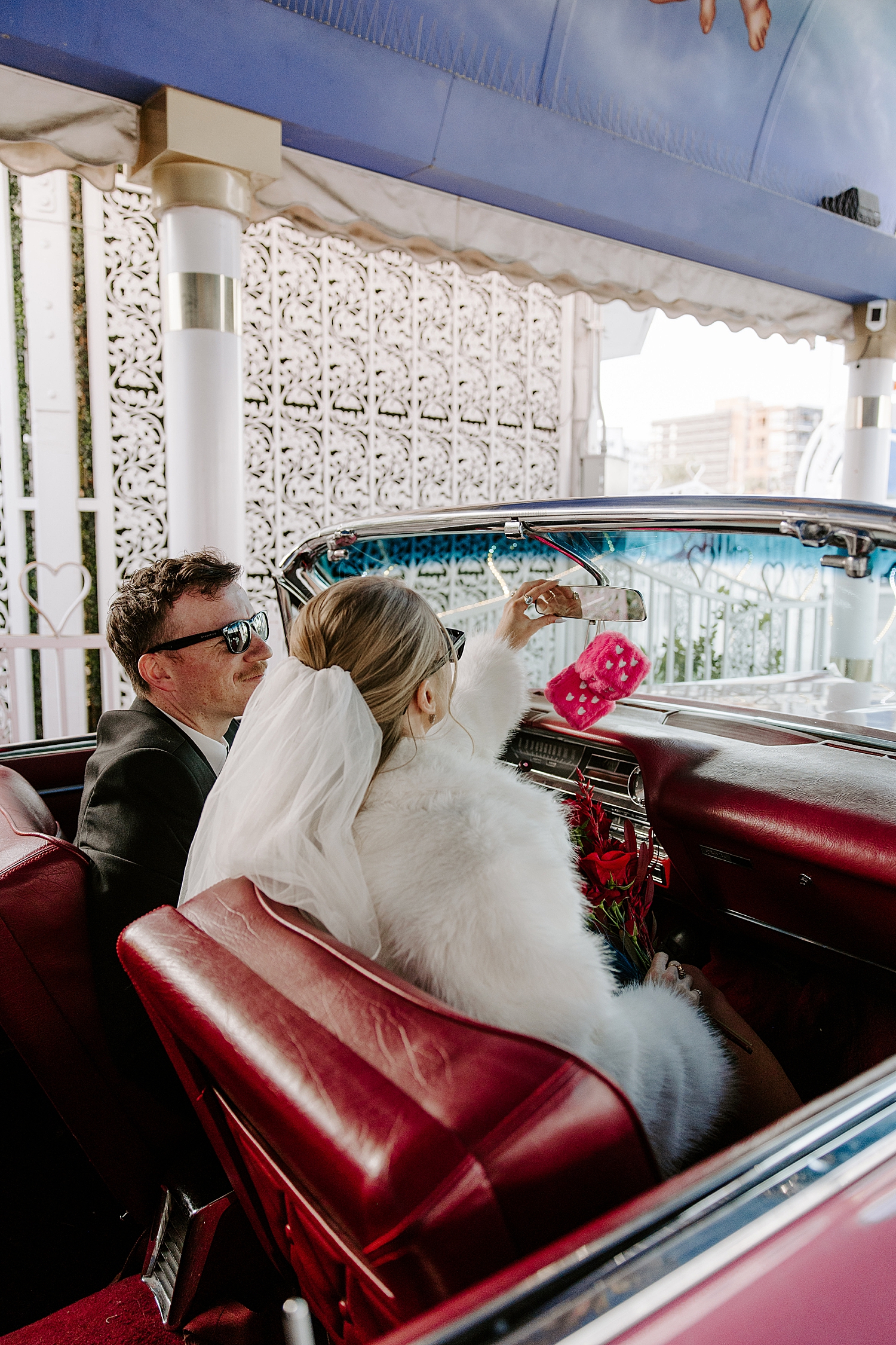 couple sit in pink Cadillac in tunnel of love after figuring out how to get married at a little white chapel